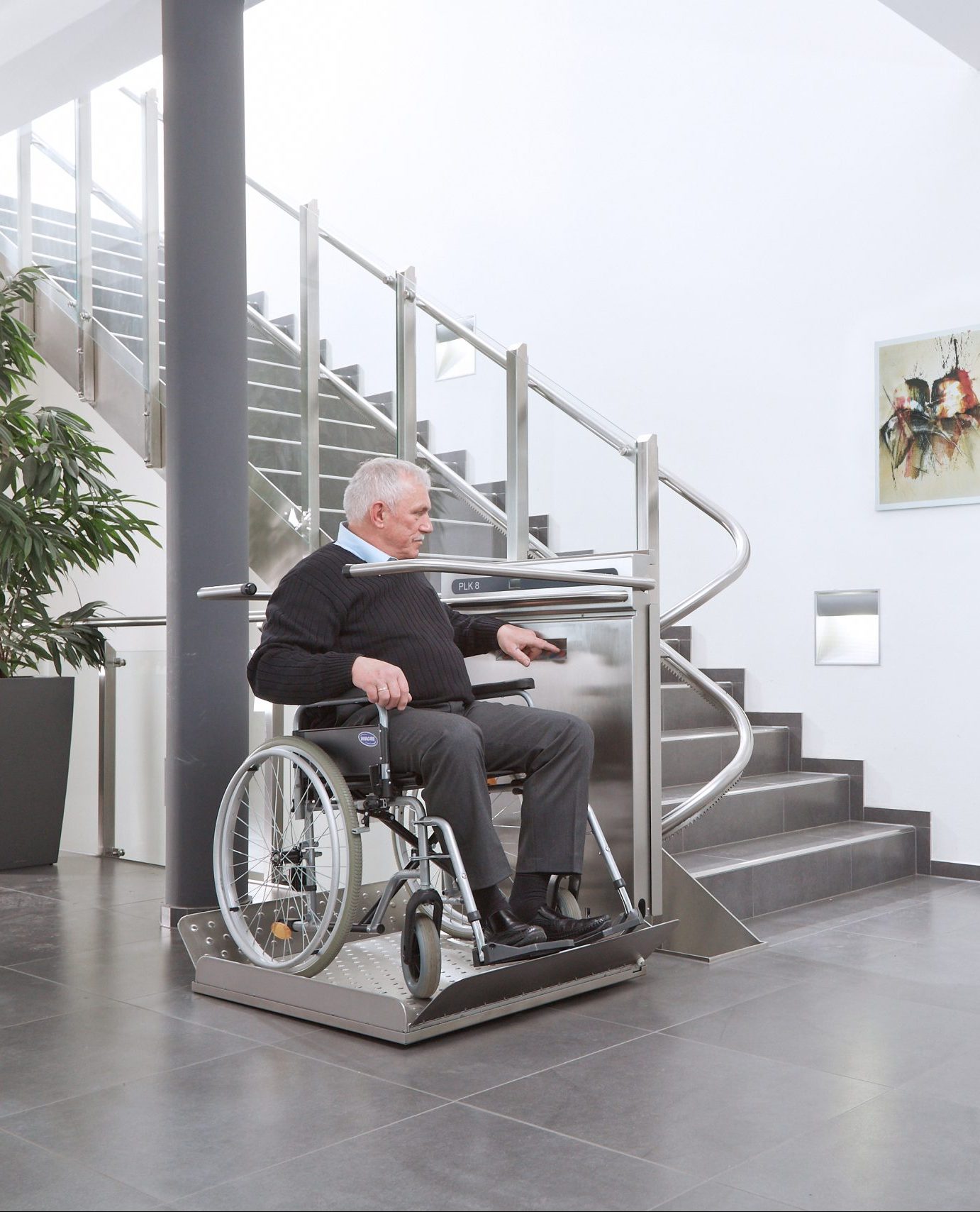 plataforma-salvaescaleras-en-uso-persona-mayor Persona mayor utilizando una plataforma salvaescaleras para surbir un tramo de escaleras